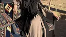 Mengenakan kerudung hitam panjang dan cadarnya, Clara Shinta memadukannya dengan gamis coklat yang memiliki aksen outer hitam berbordir.  [@clarashintareal]