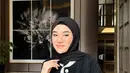 Clara Shinta tampil black on black, ia mengenakan blazer hitam fur dengan list putih. Dipadukan inner dan rok plisket warna senada.  [@clarashintareal]
